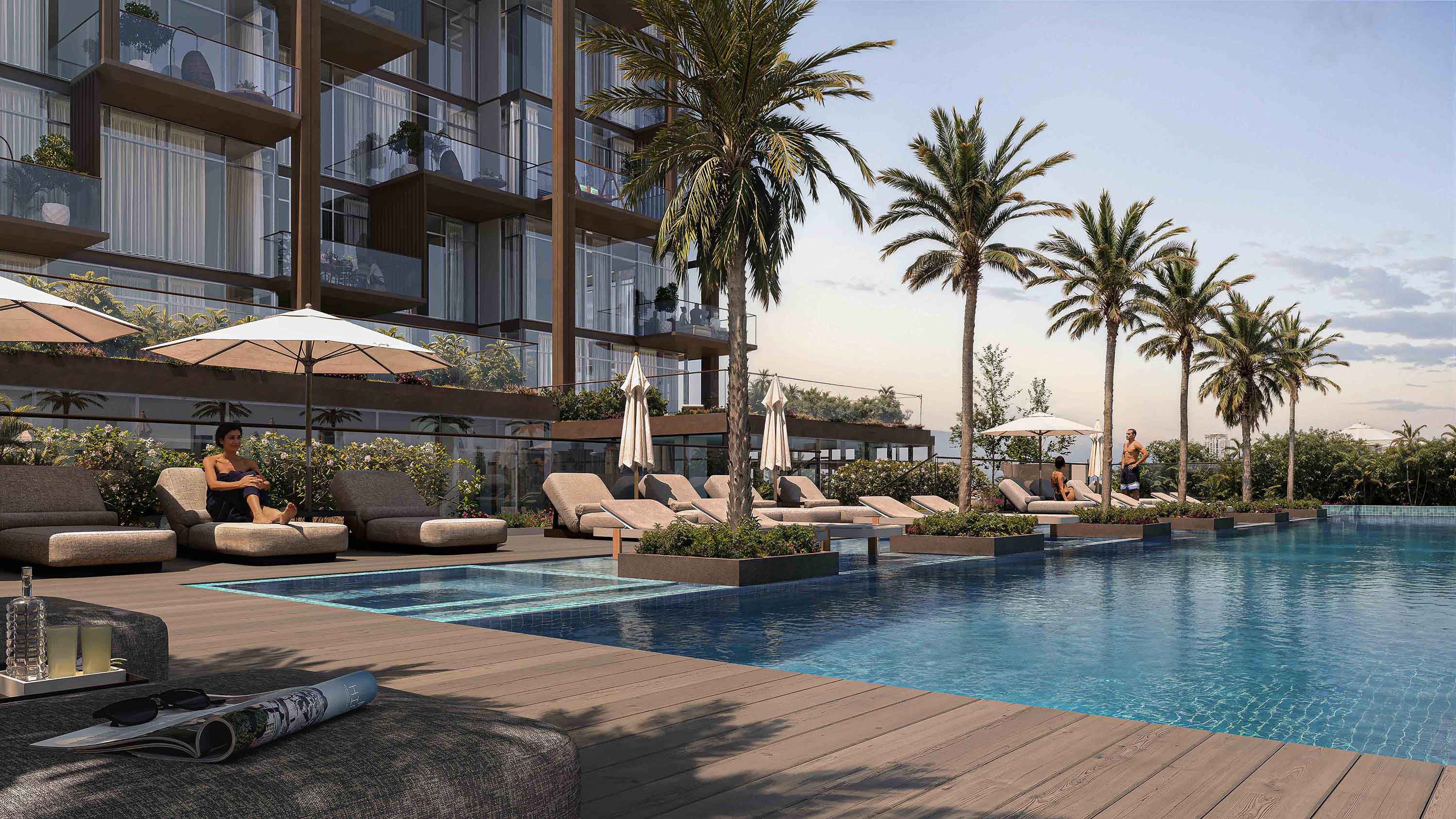 Wynwood Horizon By Imtiaz A serene pool area with lounge chairs, umbrellas, and palm trees beside a modern building, inviting relaxation.